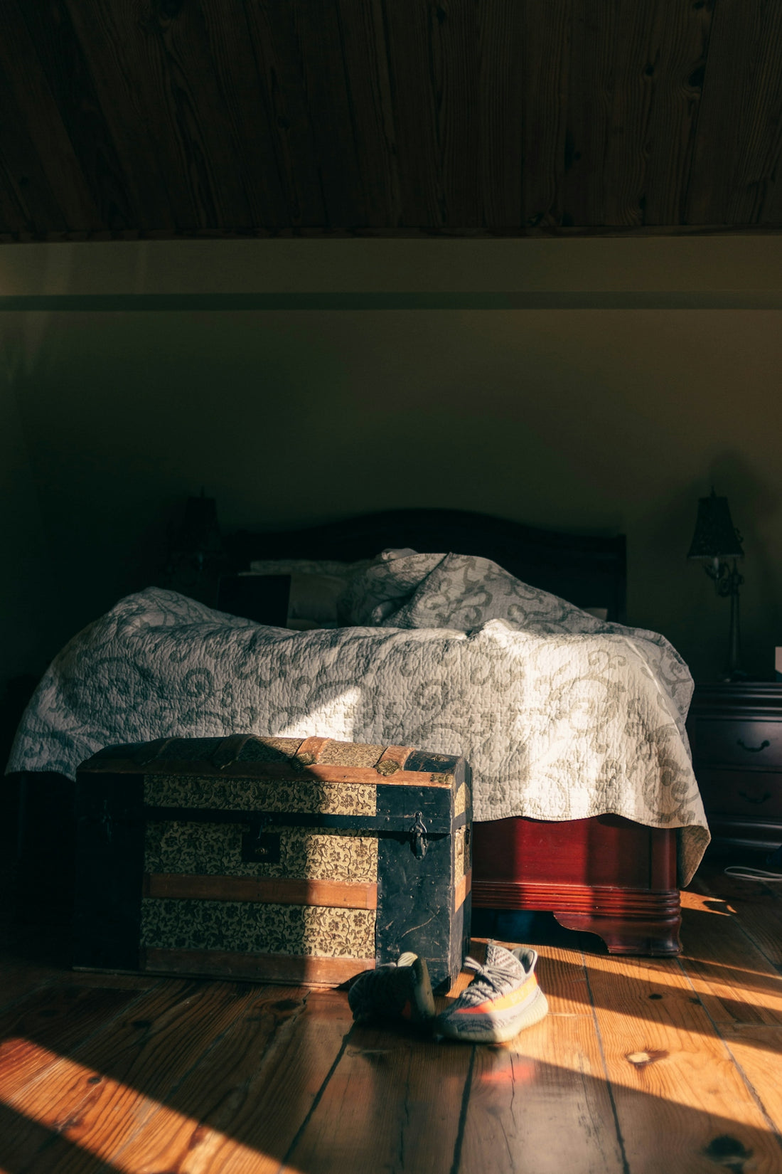 a bed sitting on top of a wooden floor next to a dresser
