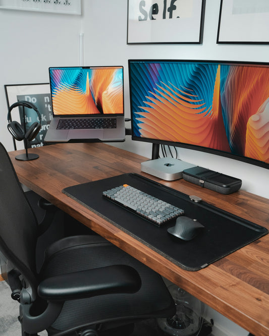 a desk with two monitors and a keyboard
