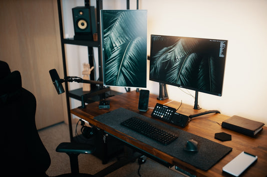 a desk with a keyboard, monitor and speakers