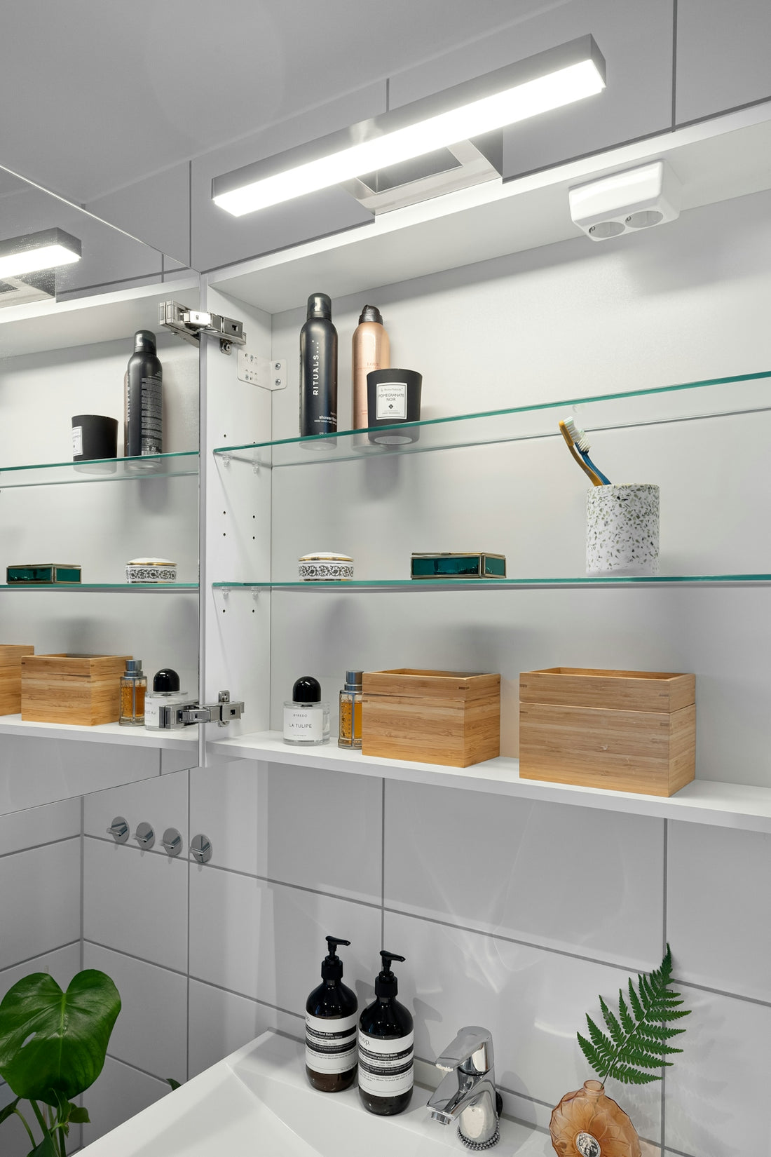 A bathroom with a sink, mirror and shelves