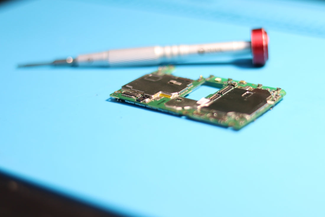 Circuit board with screwdriver on a blue surface.