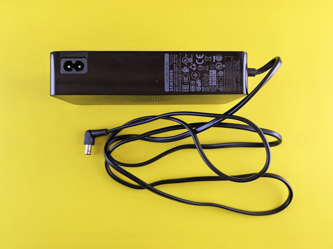 Black power adapter with cord on yellow background