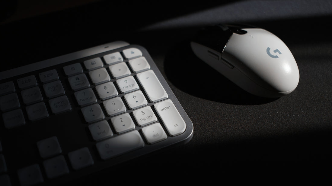 White computer mouse and keyboard in shadow