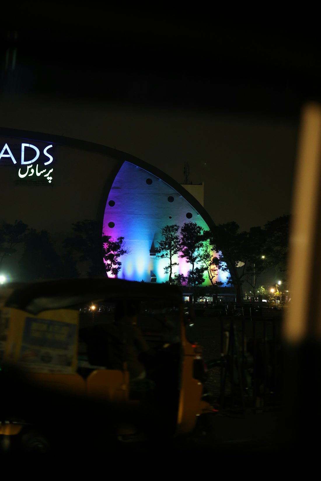 Modern building illuminated with colorful lights at night.