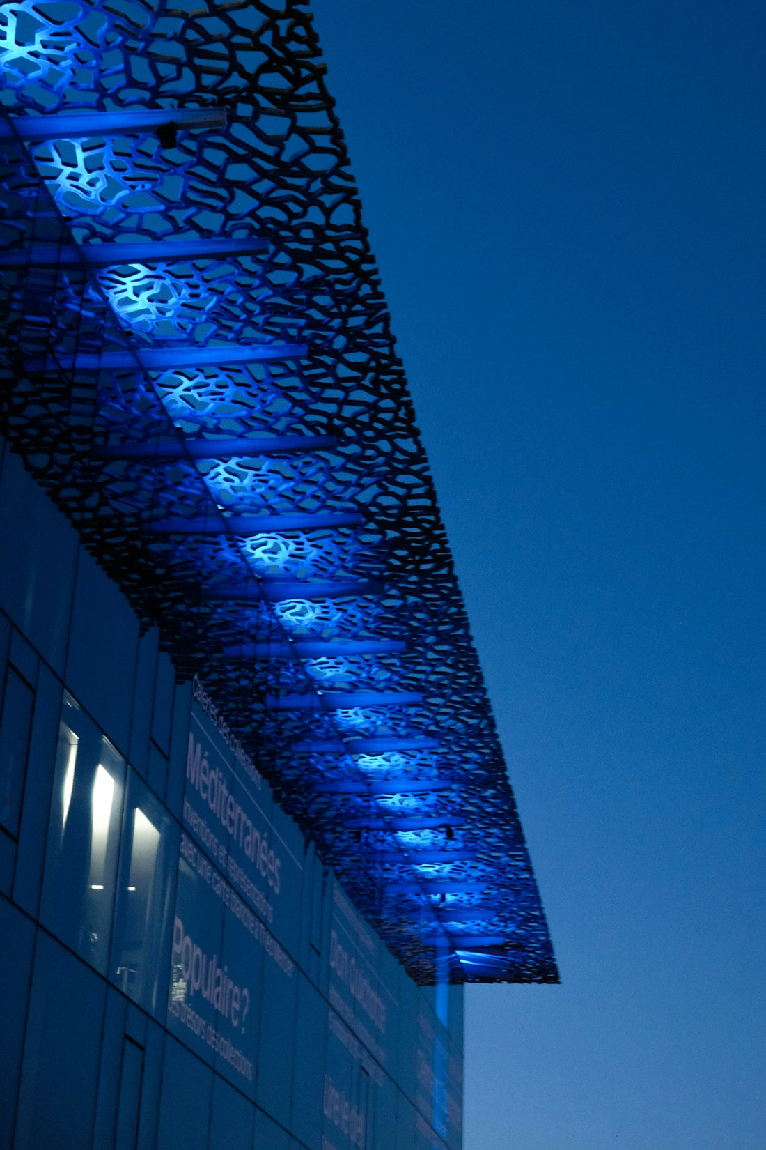 Modern building with blue lights at dusk