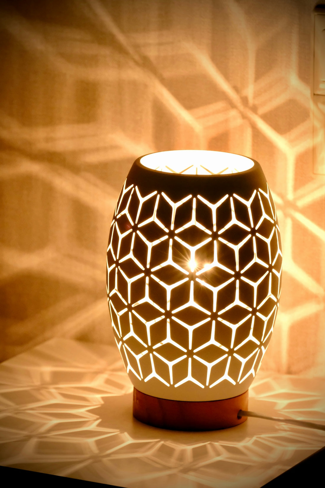 A decorative lamp casting geometric shadows on wall