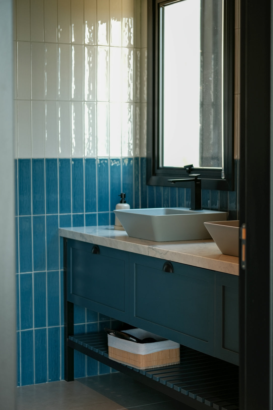 Modern bathroom vanity with blue tile and vessel sinks.