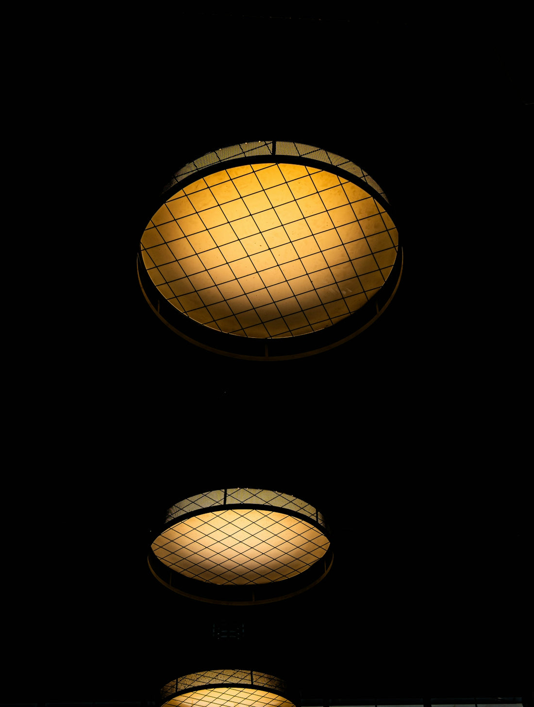 Two illuminated ceiling lights against a dark background.