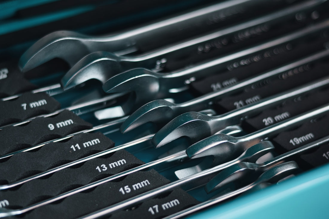 A set of metal wrenches in a toolbox